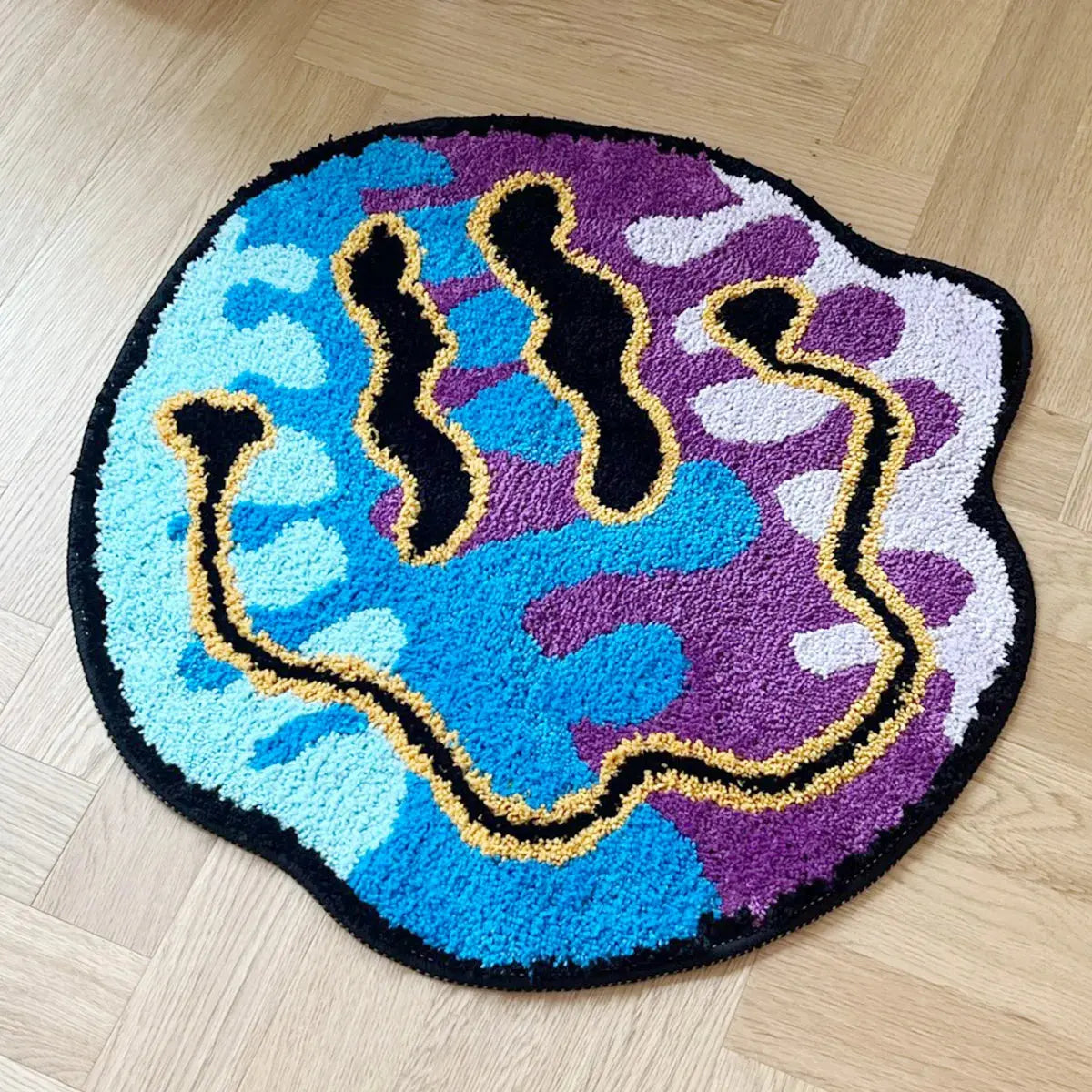 Round rug with colorful abstract design on a wooden floor