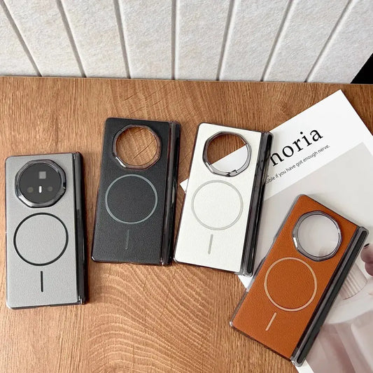 Four phone cases in different colors on a wooden surface with a magazine underneath.