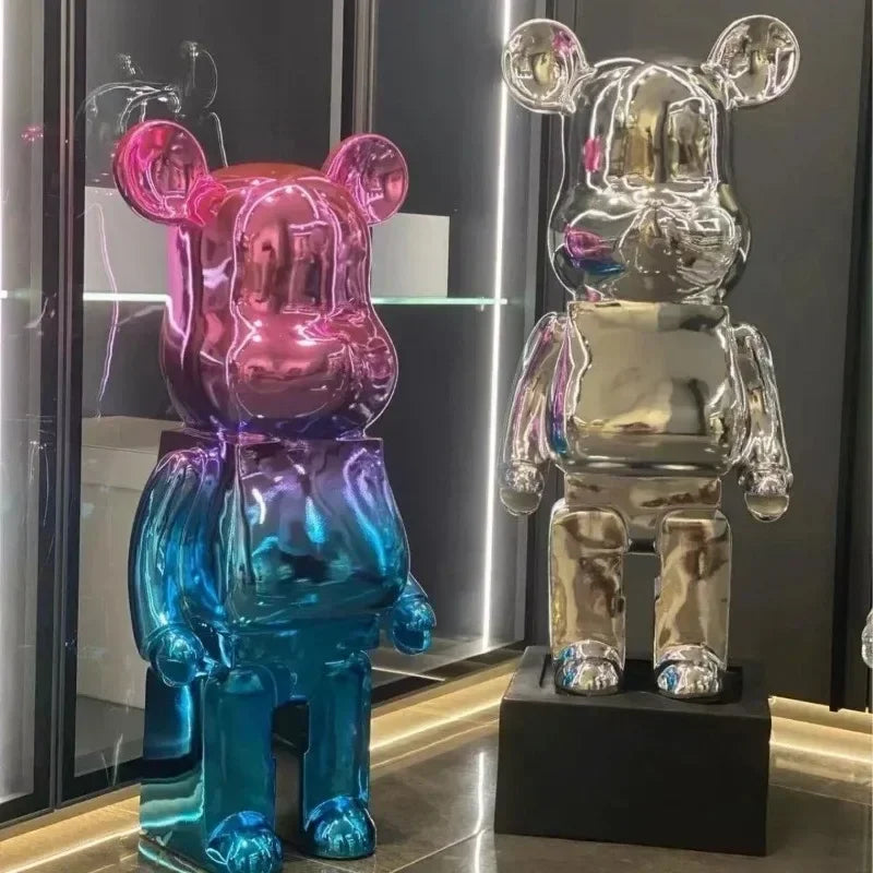 Two colorful bear-shaped figures on a reflective surface with a blurred background bearbrick collectable
