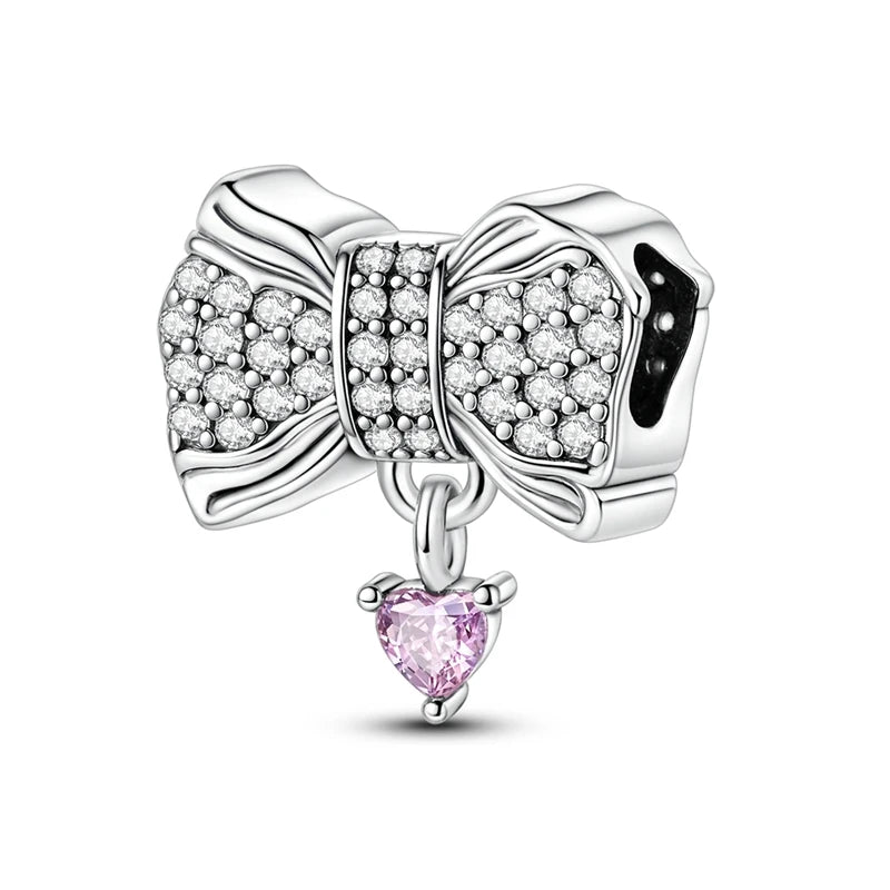 Silver bow charm with a pink heart pendant on a white background. pandora style
