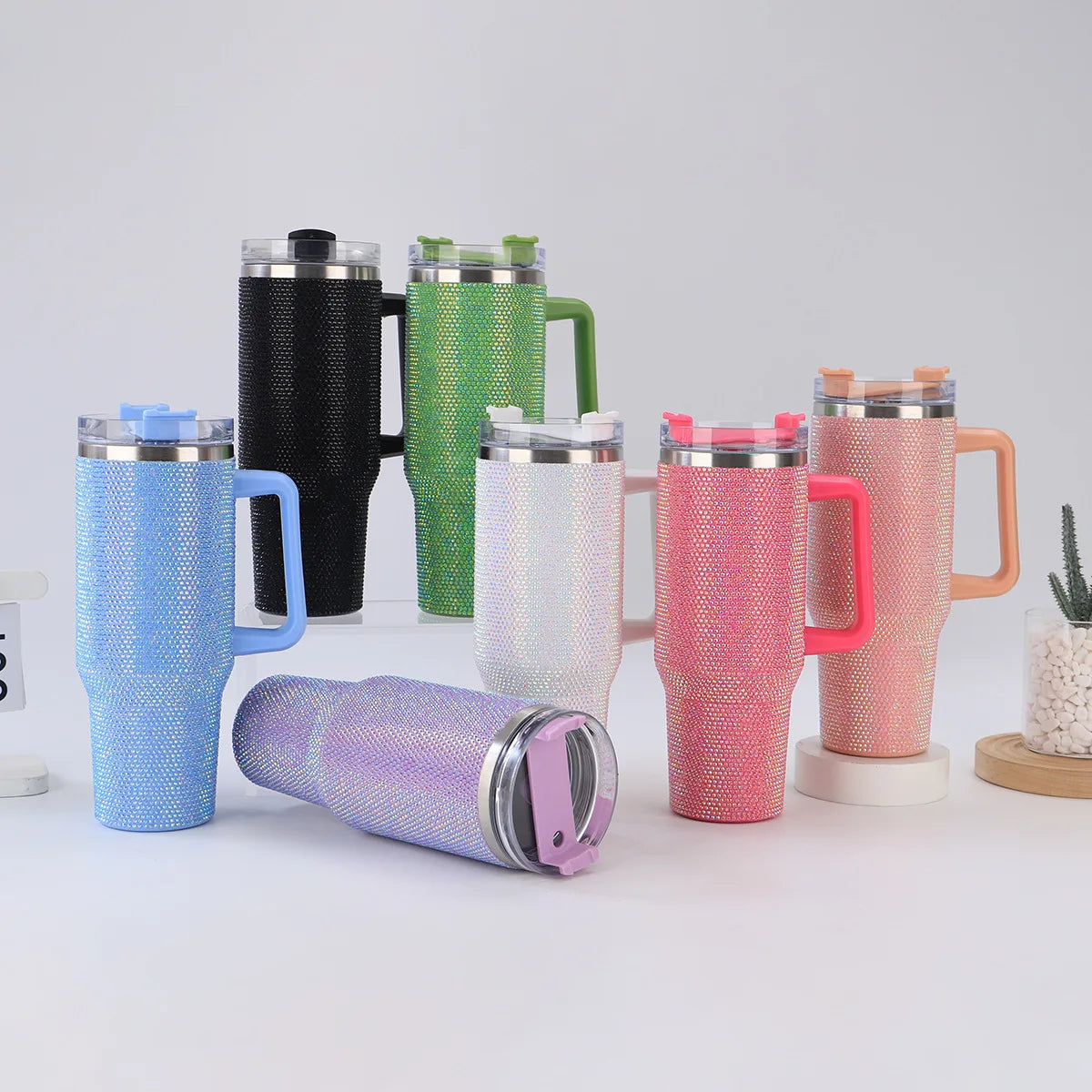Collection of colorful insulated travel mugs on a light background