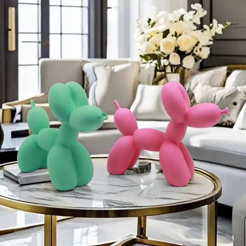 Two colourful balloon dog sculptures on a marble coffee table in a living room.