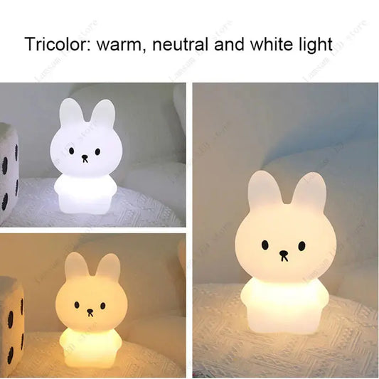Cute rabbit-shaped night light showing tricolor lighting on a soft surface.