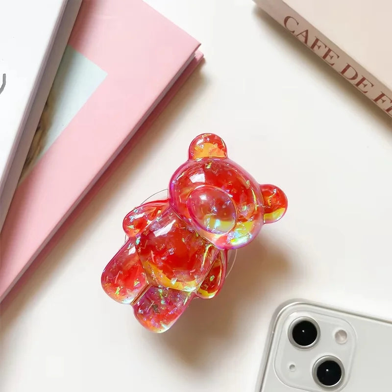 Colorful jelly-like phone case on a light surface with a phone and books in the background