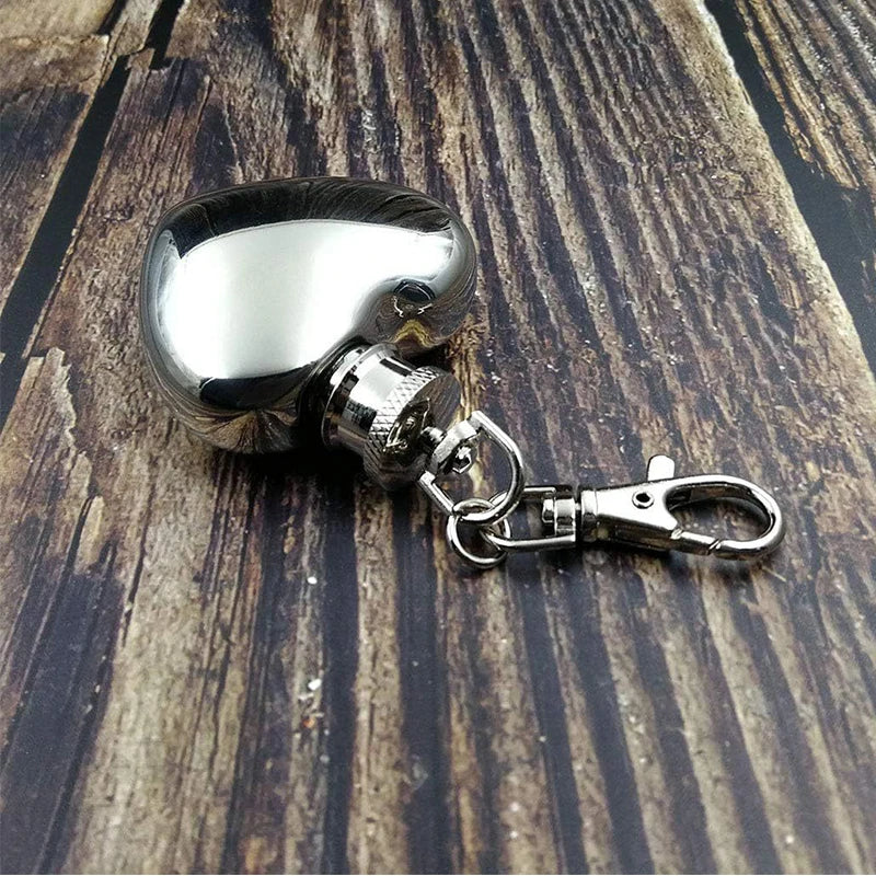 Metallic keychain with a reflective surface on a wooden surface