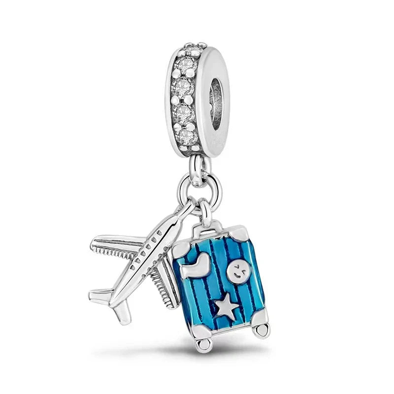 Pandora charm with airplane, suitcase, and heart design on a white background