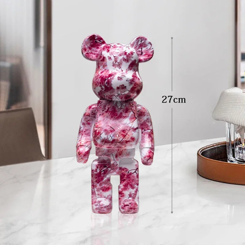 Pink and white marbled bear-shaped figure on a table with a measurement label be@rbrick collectable