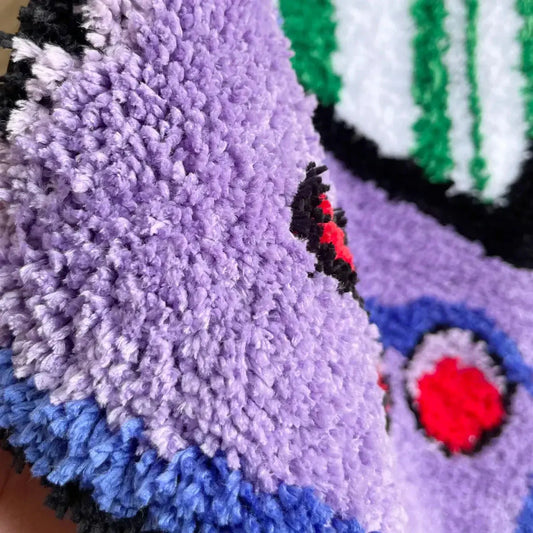 Close-up of a textured purple and blue fabric with colorful patterns.