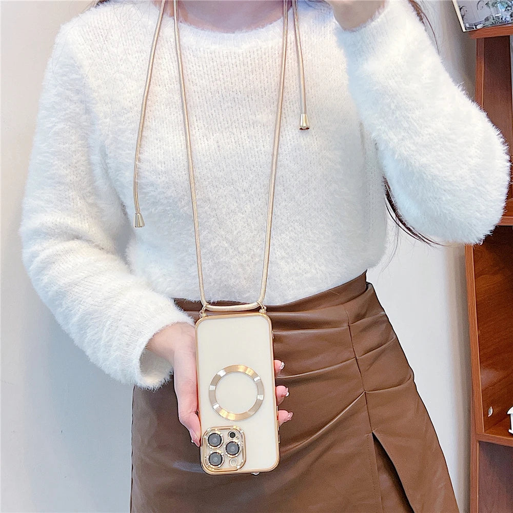 Person holding a phone case with a gold chain, wearing a white sweater and brown skirt.