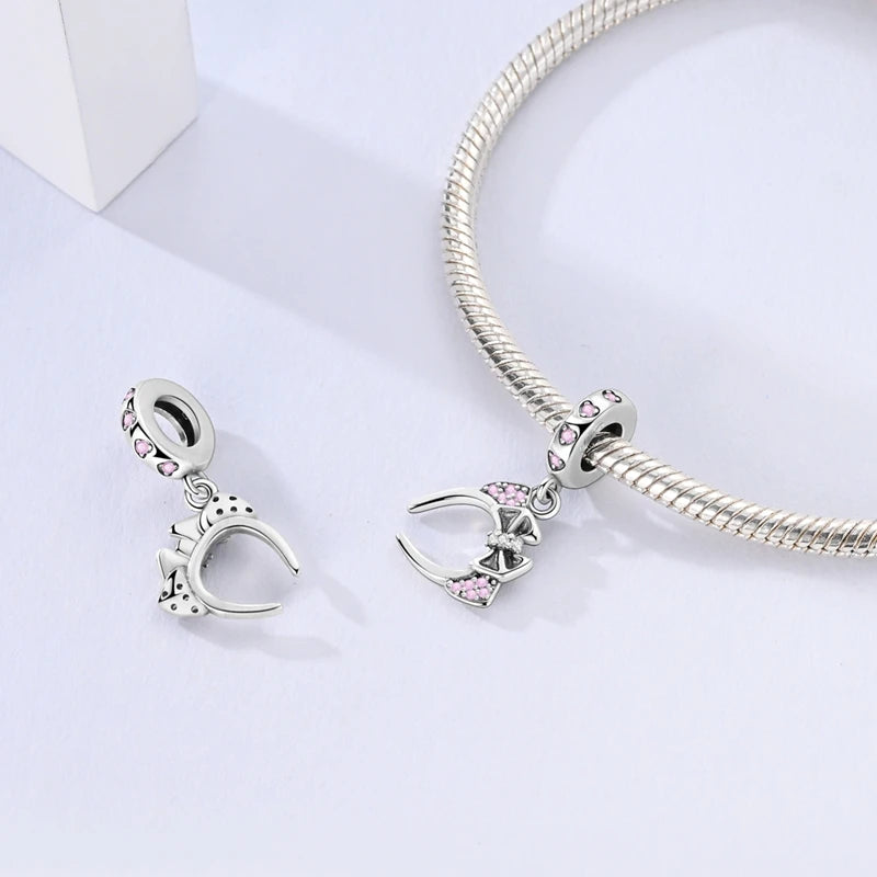Silver bracelet with headband charms on a light gray background. pandora style