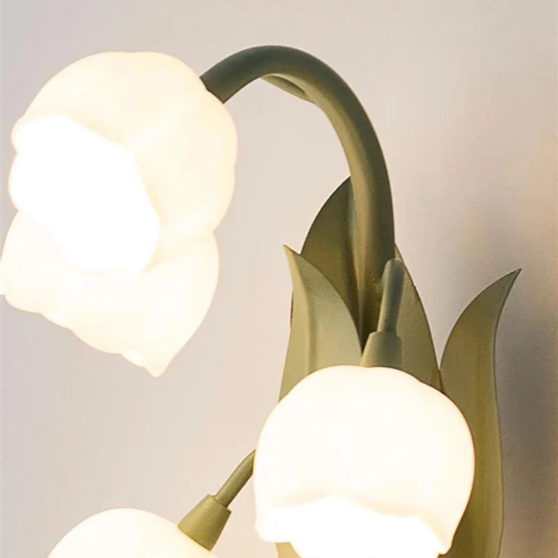 Decorative wall light fixture with three lampshades on a neutral background