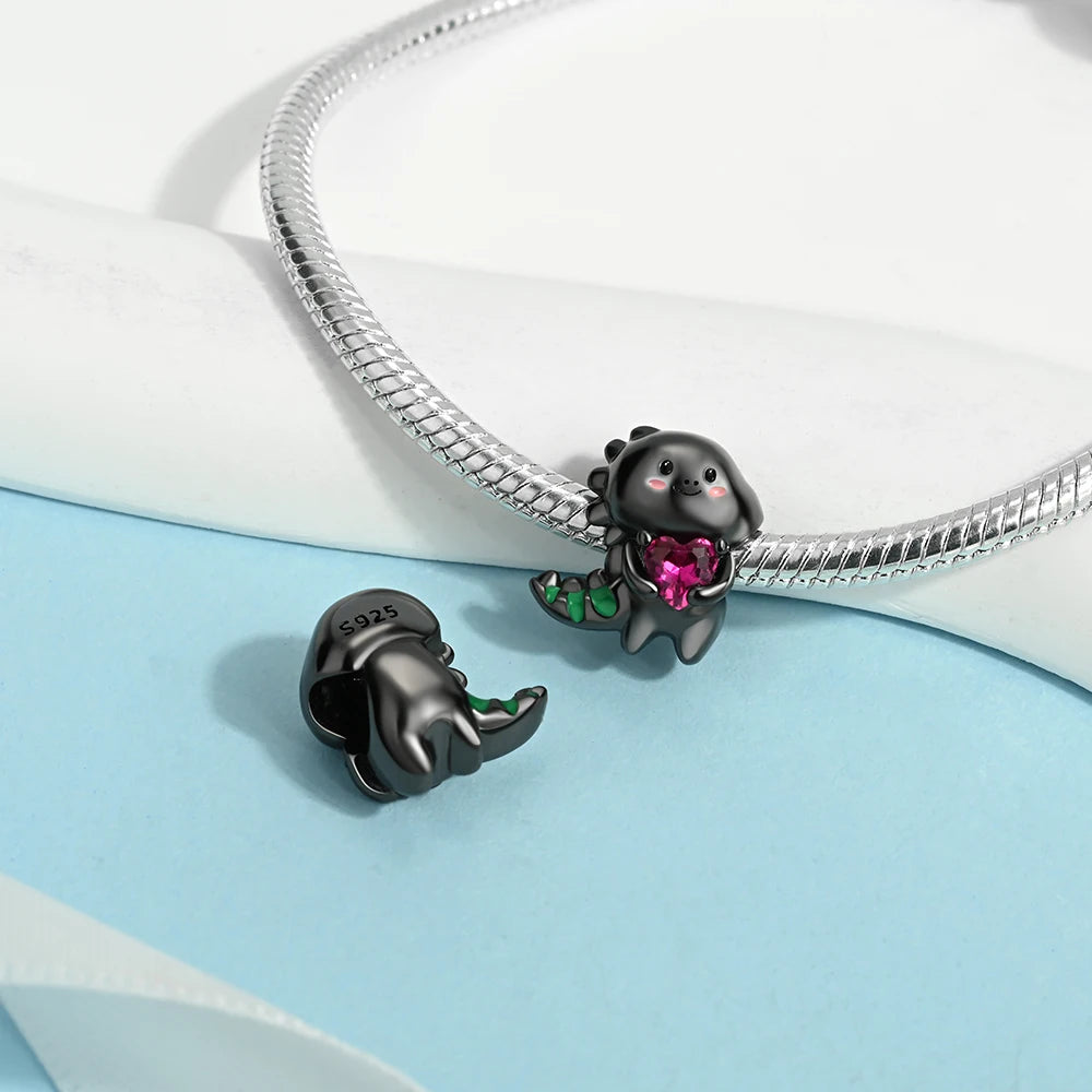 Black animal-shaped charm with a pink gem on a snake chain against a light blue and white background. pandora style charm pendant