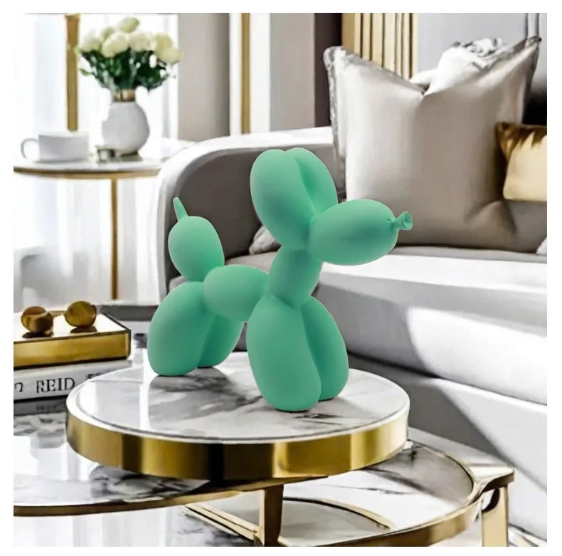Turquoise balloon dog sculpture on a marble table in a stylish living room.