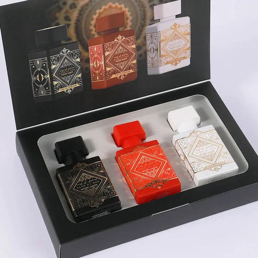 Set of four perfume bottles in a black box on a white background