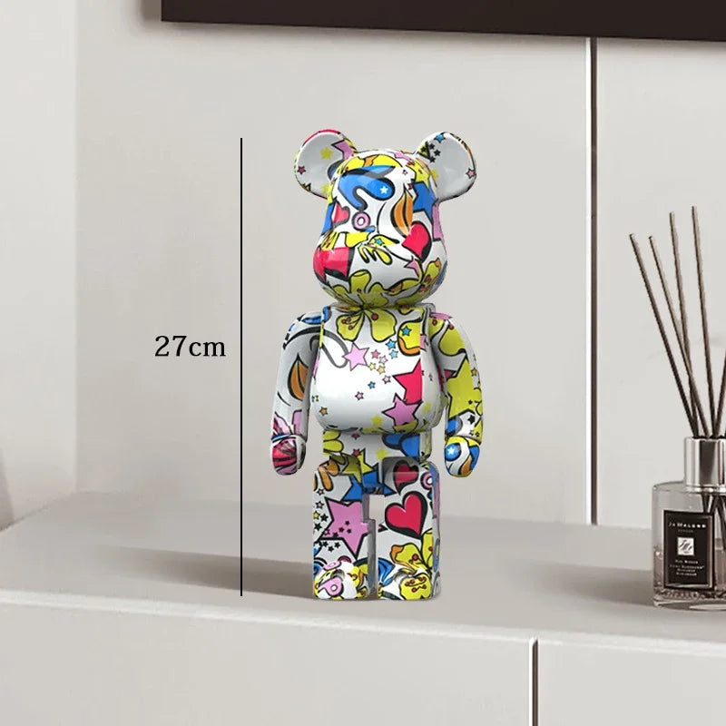 Colorful bear-shaped figure on a white surface with a measurement label, next to a diffuser. be@rbrick collectable