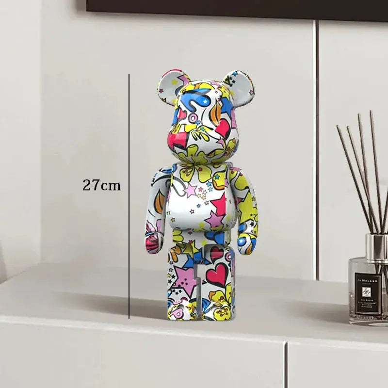 Colorful bear-shaped figure on a white surface with a measurement label, next to a diffuser. be@rbrick collectable