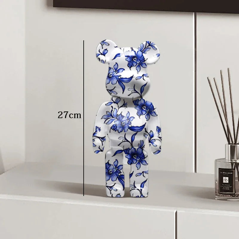Decorative bear figure with blue floral patterns on a white surface, next to a diffuser. be@rbrick collectable