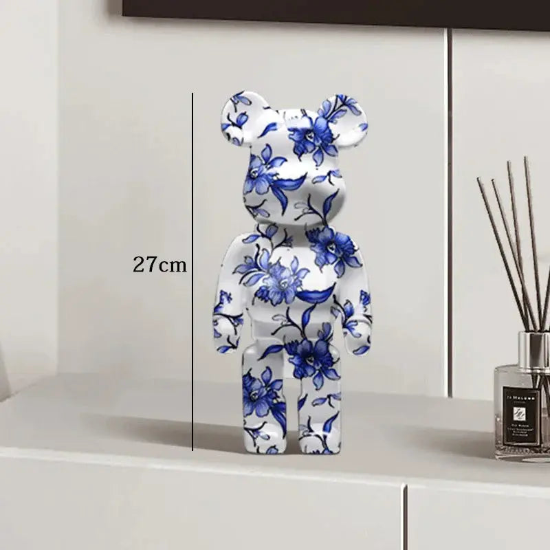 Decorative bear figure with blue floral patterns on a white surface, next to a diffuser. be@rbrick collectable