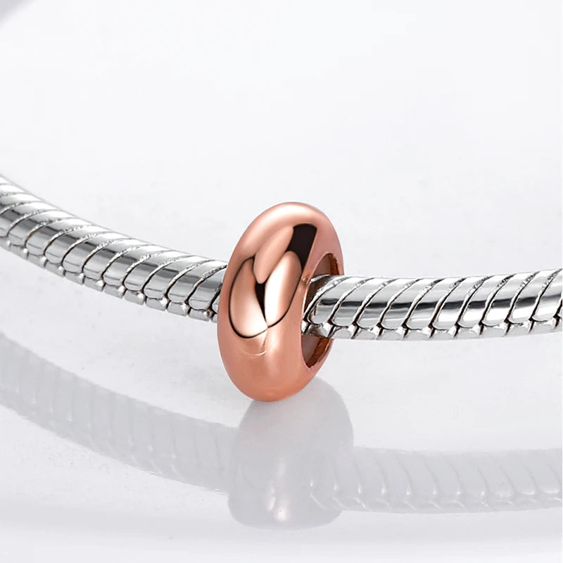 Rose gold charm on a silver snake chain against a white background
