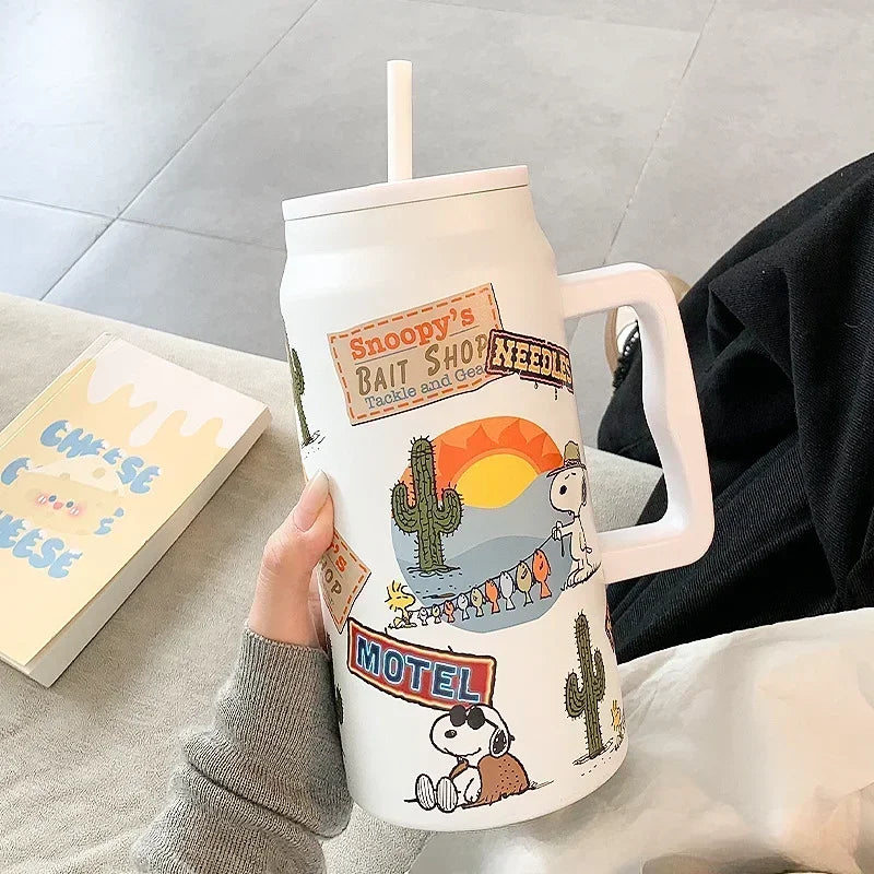 Snoopy Tumbler with Snoopy design held by a person on a light gray surface.