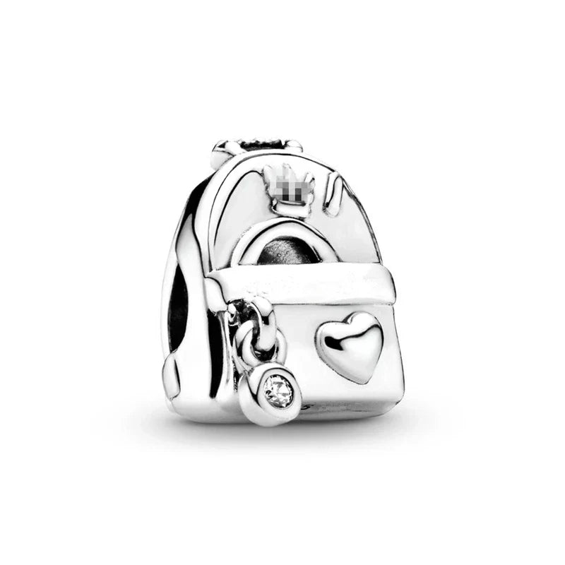 Silver charm with a heart and small round element on a white background
