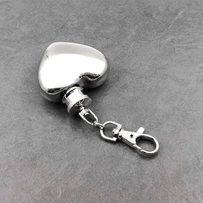 Metallic heart-shaped keychain with clasp on a gray surface
