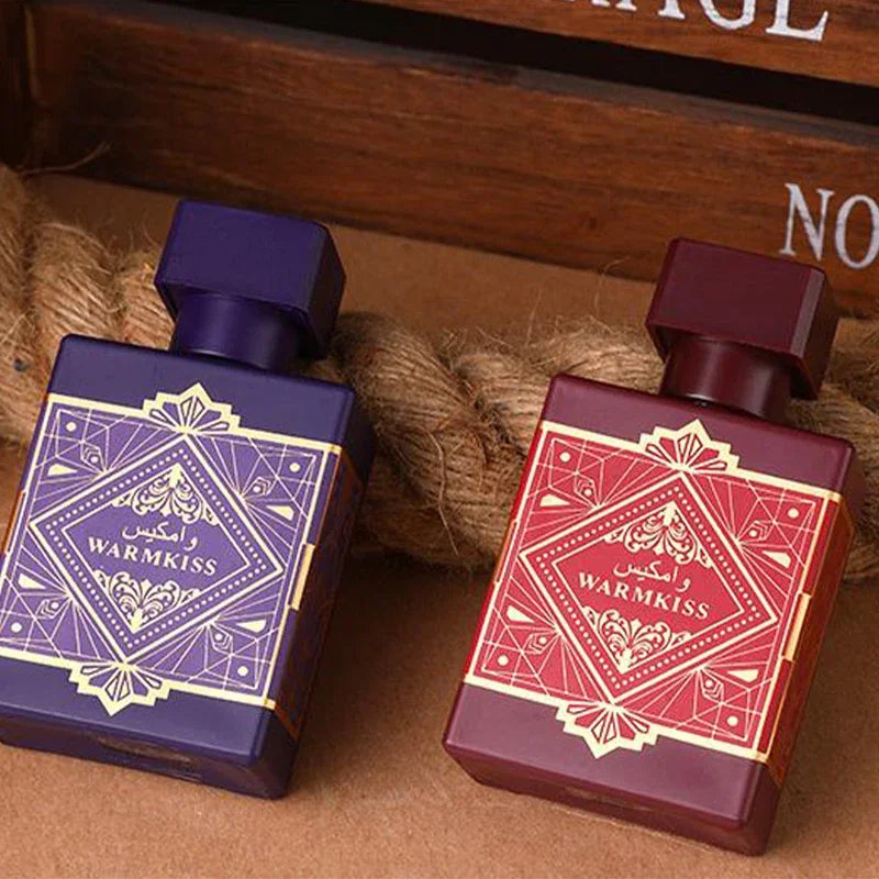 Two perfume bottles with decorative labels on a wooden surface
