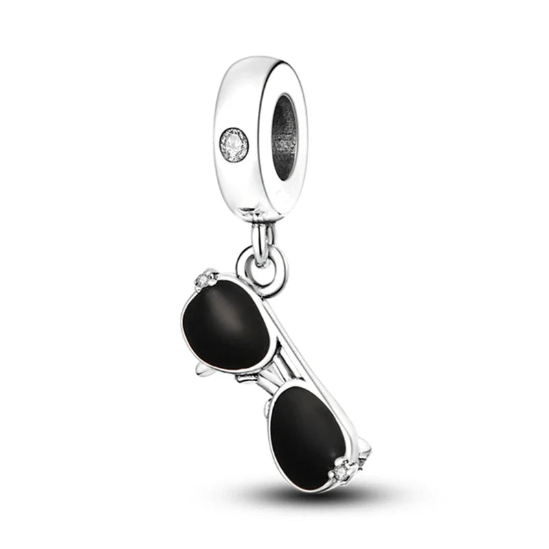 Silver charm shaped like sunglasses with black lenses on a white background