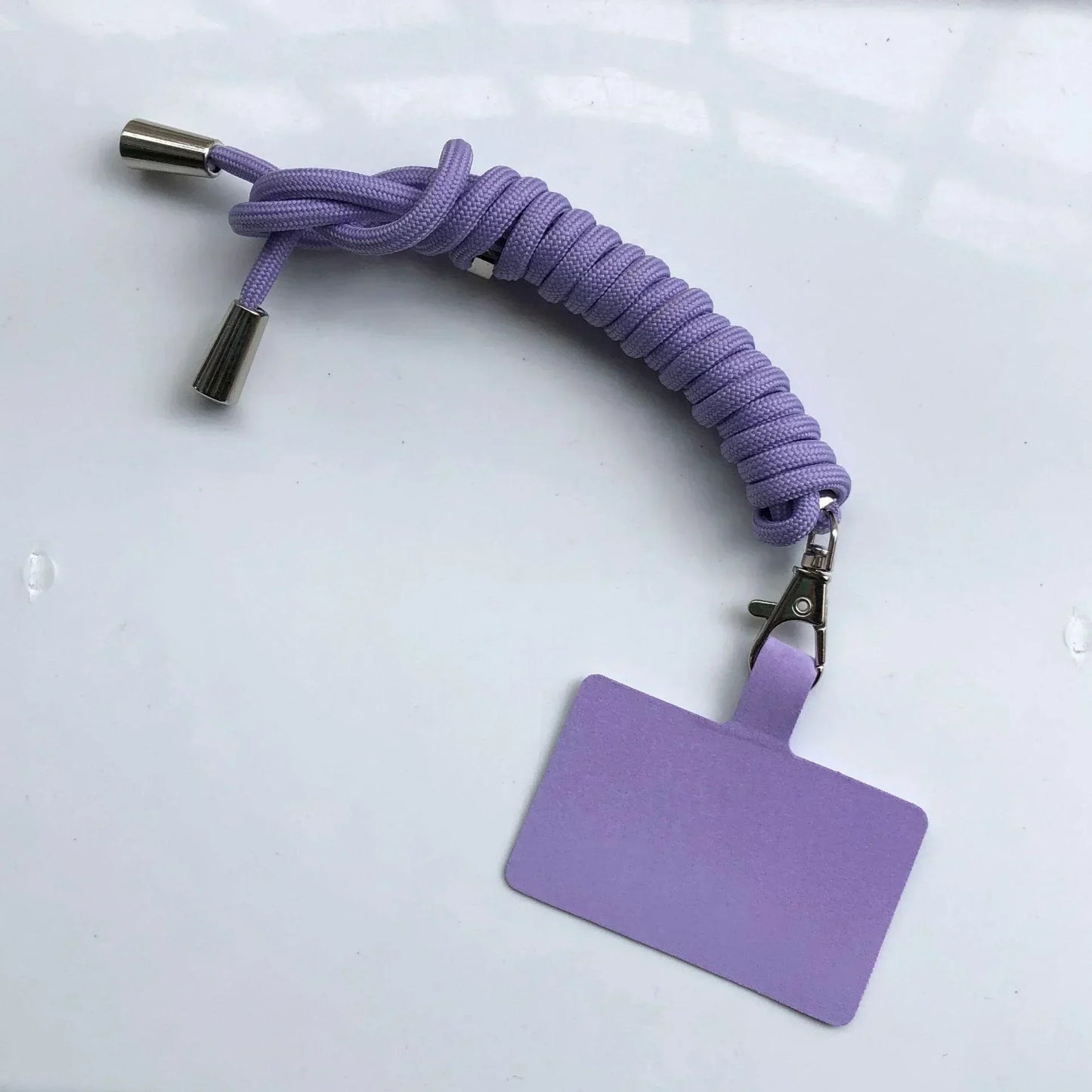 Purple braided lanyard with a square badge holder on a light gray background