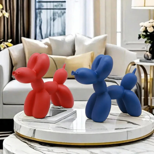 Red and blue balloon dog sculptures on a round marble table in a living room.
