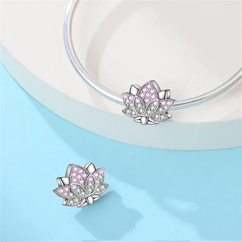 Lotus-shaped earrings with pink gemstones on a light blue background. pandora style