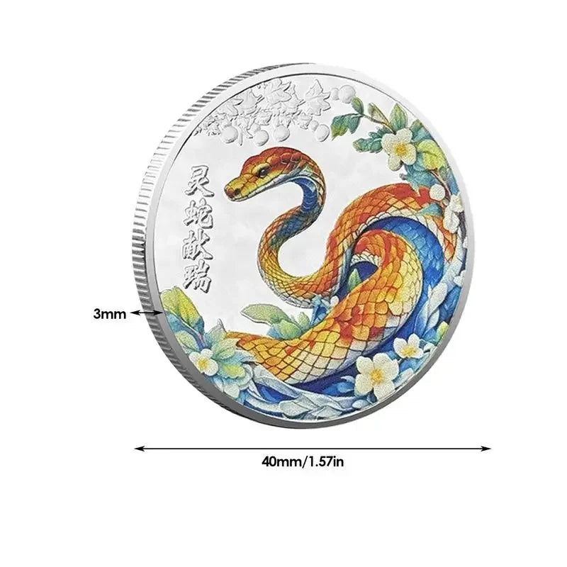 A collectible coin with a 3D relief design of a snake and floral patterns, predominantly in gold and silver colors.