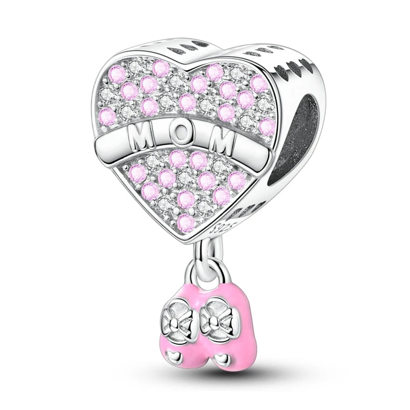 Heart-shaped charm with 'MOM' and pink gemstones on a white background