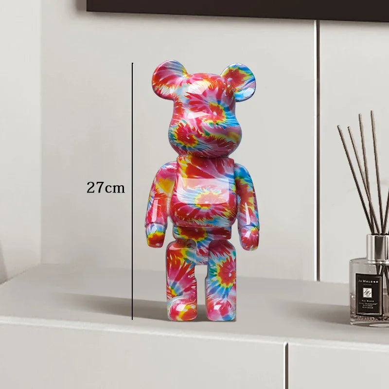 Colorful tie-dye bear figure on a white surface with a diffuser in the background be@rbrick collectable