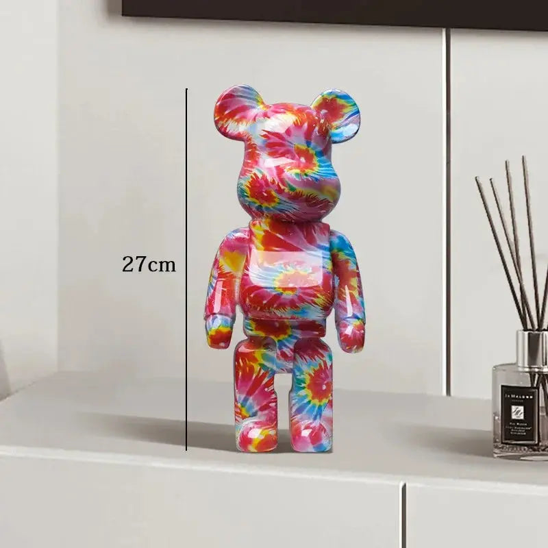 Colorful tie-dye bear figure on a white surface with a diffuser in the background be@rbrick collectable