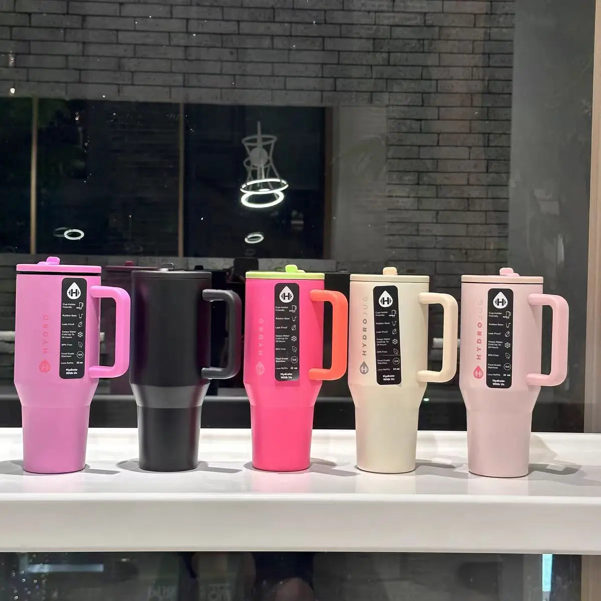 HydroJug Gobelet 40OZ Voyageur Thermos in five vibrant colors with ergonomic handles and circular flip straws, ideal for daily hydration.