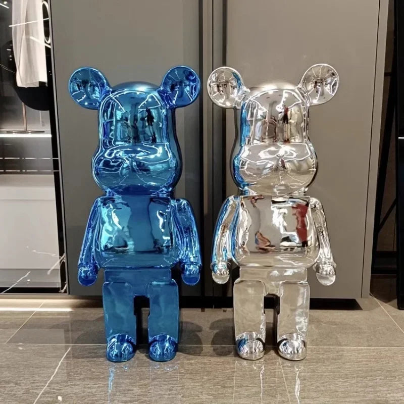 Blue and silver transparent bear-shaped sculptures on a reflective surface. bearbrick collectable