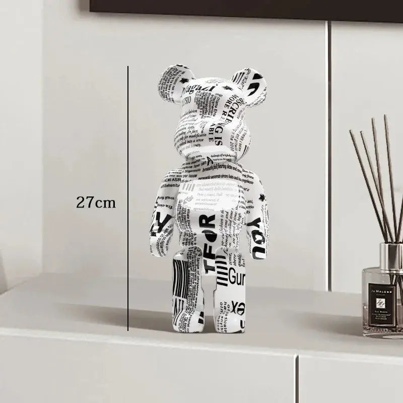 Black and white bear figure with text on a shelf next to a diffuser be@rbrick collectable