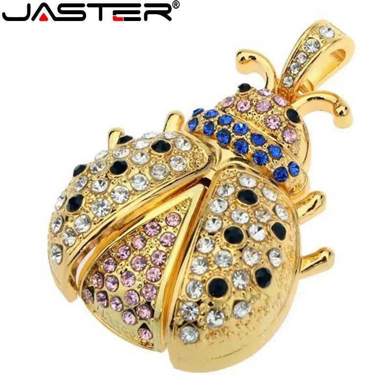 Gold beetle pendant with colorful gemstones on a white background, featuring the brand 'JASTER'.
