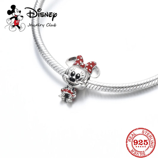 Disney jewelry club charm with red bow on a white background