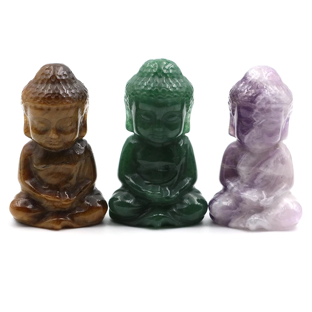 Three crystal Buddha statues in brown, green, and purple on a white background