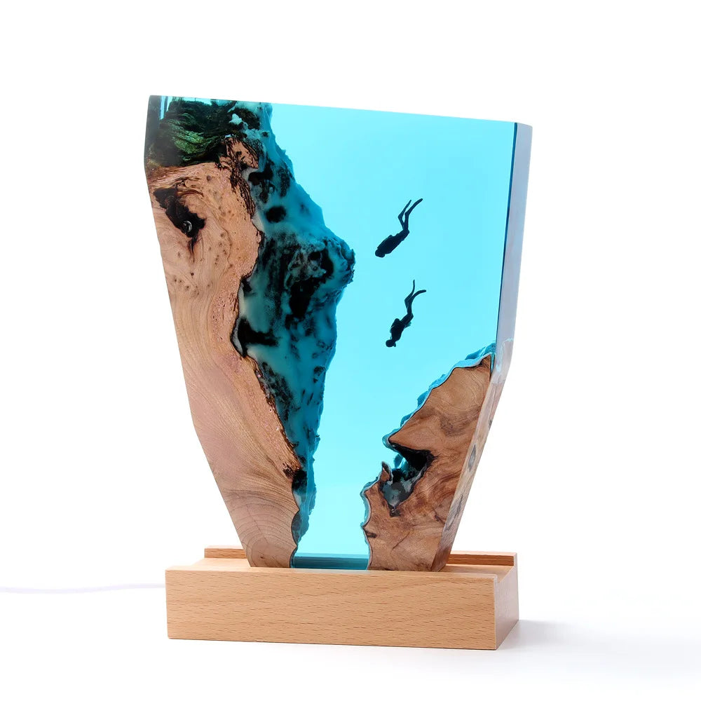 Wooden sculpture with blue resin inlay on a white background scuba divers