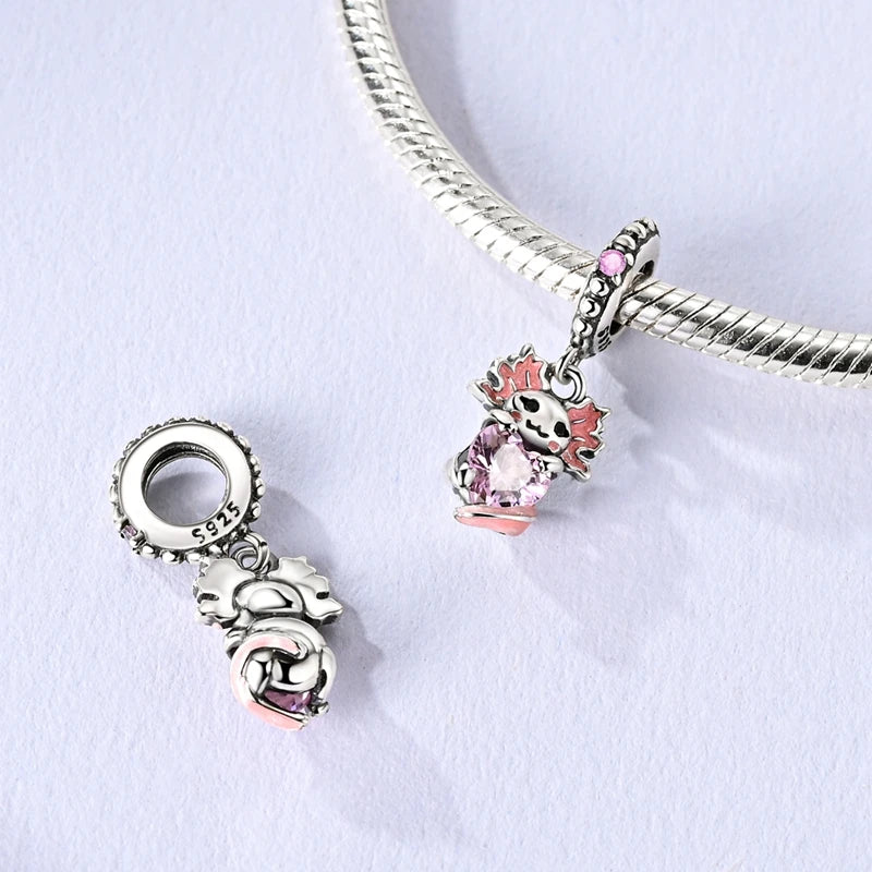Two silver charms with pink accents on a white background. pandora style