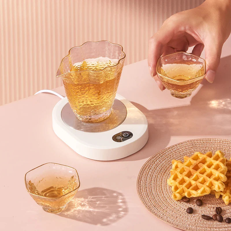 Thermostatic cup warmer heating a pitcher of tea, suitable for small flat-bottomed containers in kitchen or dining settings.