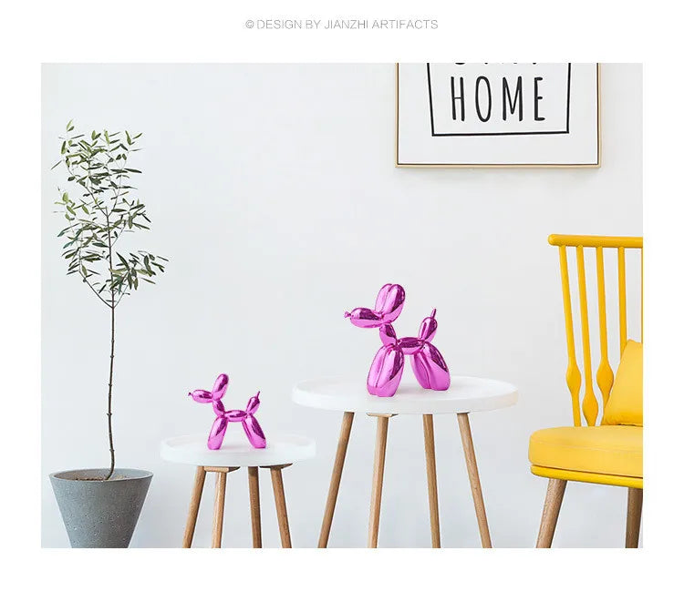 Pink balloon dog sculptures on small tables with a yellow chair and plant in a minimalistic room.
