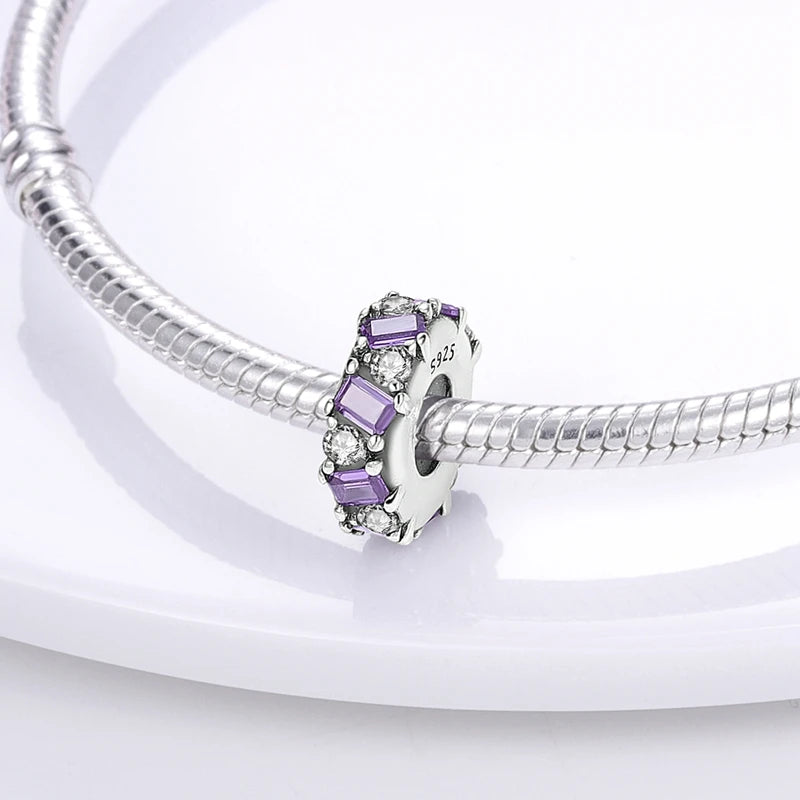 Silver bracelet with a purple charm on a white background