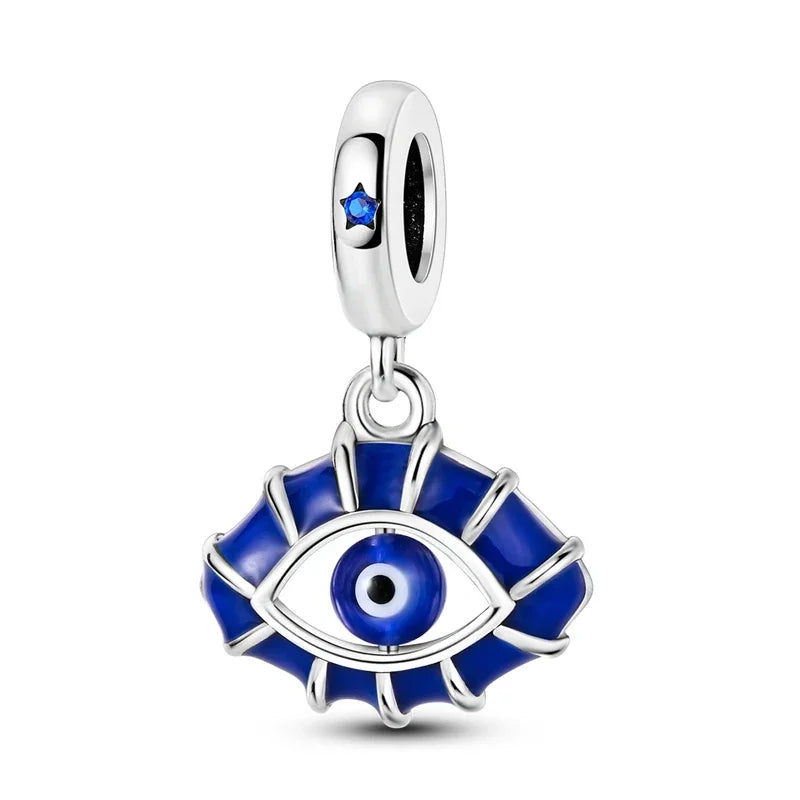 Silver charm with blue eye design on a white background