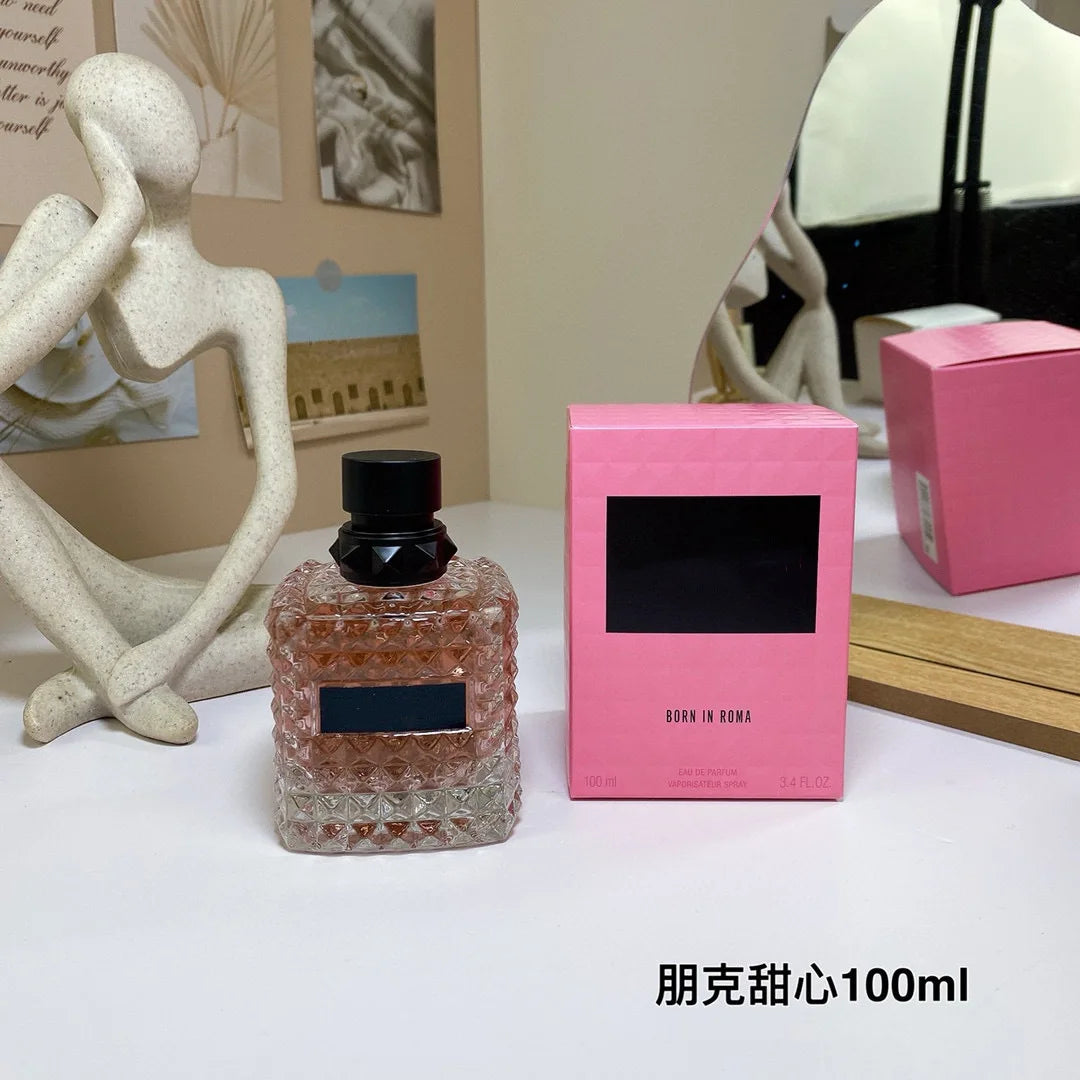Valentino Perfume bottle and pink box on a table with decorative items in the background