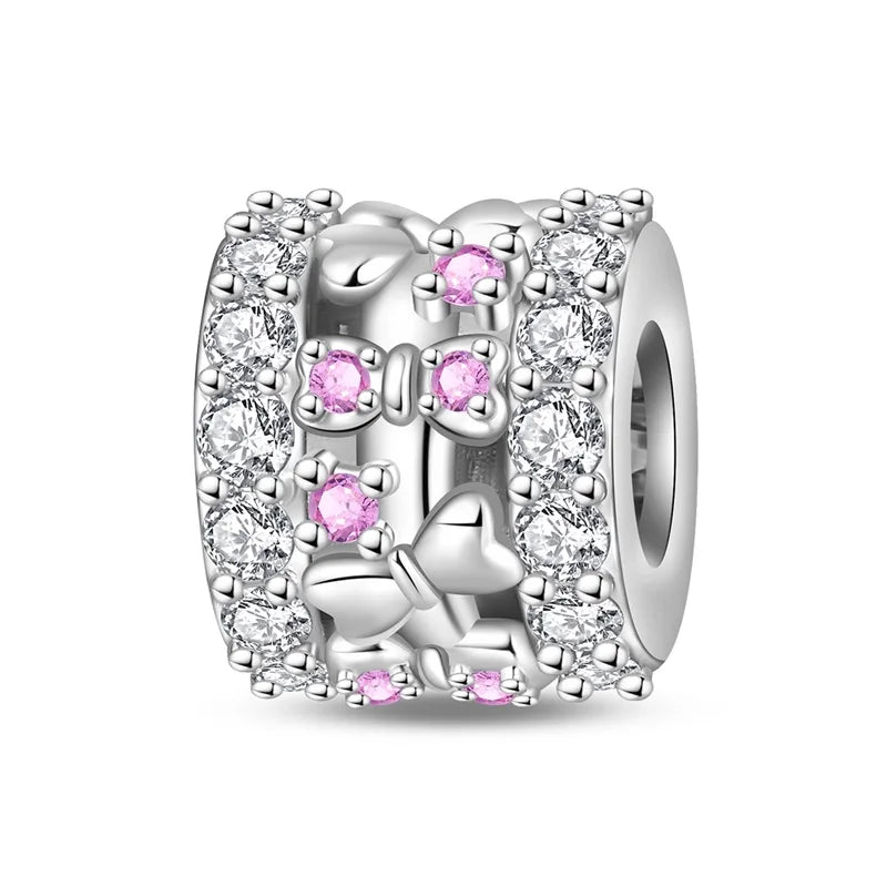Silver charm with pink gemstones on a white background