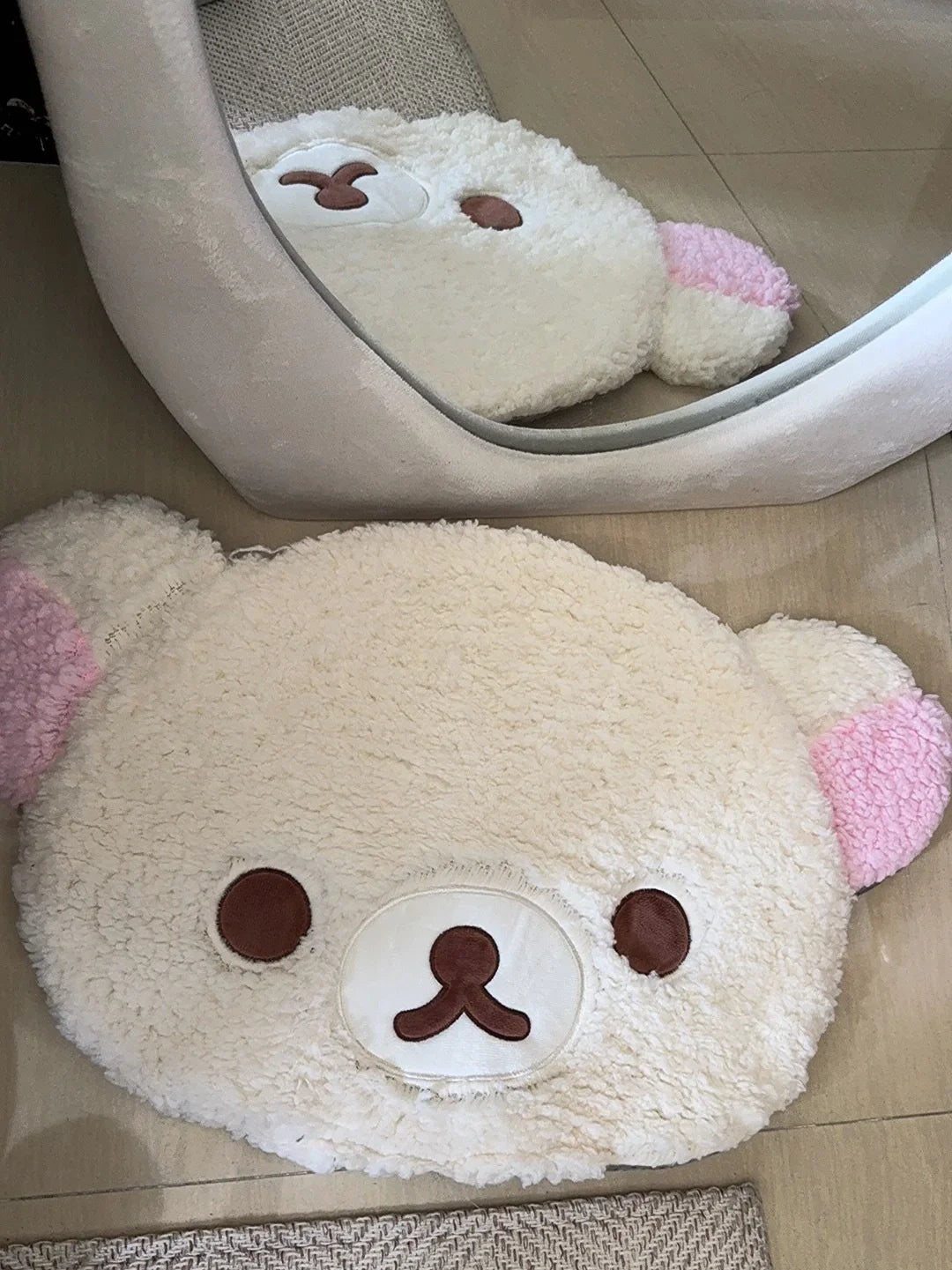 Plush bear-shaped car seat cover on a car seat